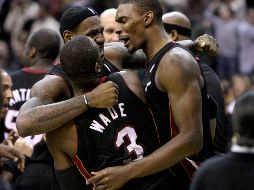 Lebron James abraza a sus compañeros Dwyane Wade y Chris Bosh, en el partido de ayer. AP  /