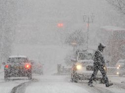 Un peatón cruza la calle durante una caída de nueve en el Centro de Londres. AP  /