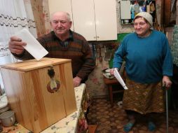Una pareja deposita sus papeletas en casa para votar en las elecciones presidenciales, en Selets, Bielorrusia. EFE  /