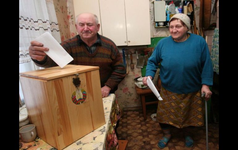 Una pareja deposita sus papeletas en casa para votar en las elecciones presidenciales, en Selets, Bielorrusia. EFE  /