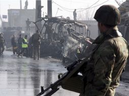 Soldados afganos inspeccionan los restos de un autobús militar tras el ataque. EFE  /