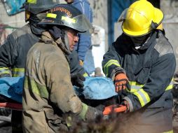 Bomberos cargan el cuerpo de una de las víctimas de la explosión en ductos de Pemex en San Martín Texmelucan. REUTERS  /