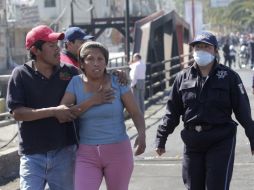 Un oficial de policía ayuda a los residentes a evacuar el lugar de la explosión. REUTERS  /