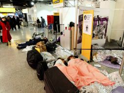 Pasajeros duermen en el aeropuerto Heathrow en Londres, luego de que sus vuelos fueran cancelados por la ola de frío. AP  /