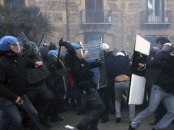 Policías cargan contra un grupo de jóvenes durante los disturbios producidos cuando miles de estudiantes se manifestaban. EFE  /