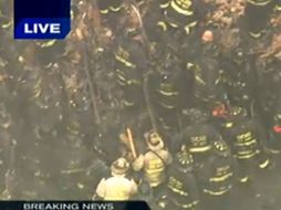 En  este marco agarrado  de WGN-TV, los bomberos de Chicago trabajan para salvar a compañeros atrapados. AP  /