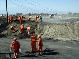 Elementos de Protección Civil realizan labores de limpieza en la zona afectada por la explosión de un ducto de PEMEX. EL UNIVERSAL  /