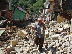 Un hombre camina de entre los escombros en Colombia. AP  /