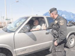 Un policía dialoga con un inmigrante mexicano que llega al país a celebrar las fiestas decembrinas. EL UNIVERSAL  /