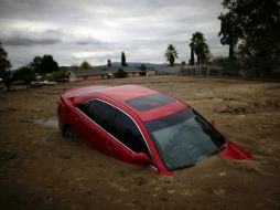 Un coche se entierra en el barro después de las inundaciones en Highland, California. AFP  /