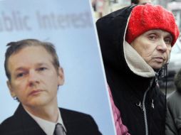 Una  seguidora del fundador de Wikileaks sostiene su foto durante una protesta frente a  la Embajada de Suecia. AP  /