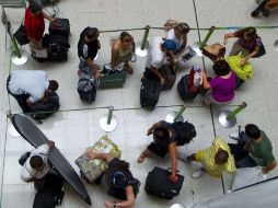Pasajeros en espera del check in para sus vuelos, en el aeropuerto Santos Dumont, de Rio de Janeiro, Brasil. AFP  /