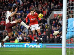 Dimitar Berbatov (c) reamta de cabeza para anotar el primer gol del partido. AFP  /