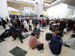 Decenas de viajeros sentados en el suelo esperando sus vuelos atrasados o cancelados. EFE  /