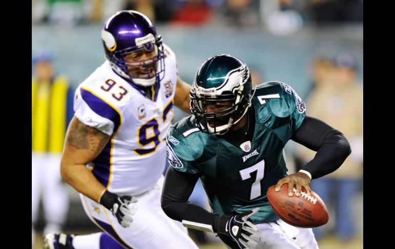 Michael Vick huye de la presión del defensivo de Minnesota durante el partido de martes por la noche. AP  /