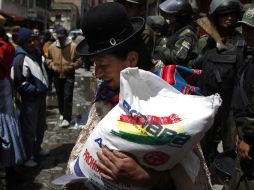 Una mujer carga un costal de azúcar subsidiado por el Gobierno. AP  /