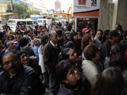 Ahorradores intentan retirar sus fondos de la caja La Primera tras los rumores de propagación de fuga de capital, en La Paz. AFP  /