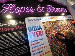 na mujer fija una pieza de confeti en el muro de deseos en el Centro de Información de Times Square. NTX  /