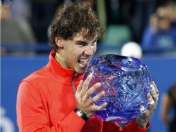 El tenista español Rafael Nadal muerde su trofeo del torneo de Abu Dhabi. REUTERS  /
