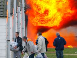 Reos salen de sus módulos para escapar del fuego en la prisión Ford, en el Reino Unido. EFE  /