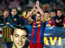 Xavi aplaude en su pequeño homenaje por igualar el récord de Miguel Bernardo Bianchetti. EFE  /