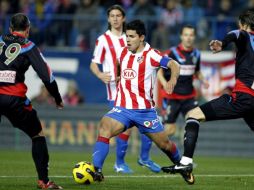 El delantero argentino del Atlético de Madrid, Sergio Kun Agüero (c), controla el balón entre los defensas del Racing de Santander. EFE  /