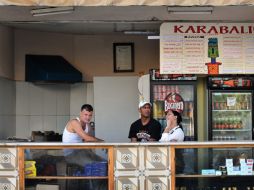 Trabajadores de una cafetería estatal conversan mientras esperan la llegada de algún cliente. EFE  /