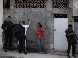 Policías brasileños catean a habitantes de las favelas en Río de Janeiro. AP  /