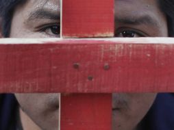 Un migrante sostiene una cruz durante la marcha de hoy en Arriga, Chiapas. AP  /