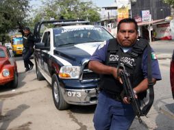 Policías corren durante un enfrentamiento con criminales en Acapulco, donde ya se registran 24 muertos tras una jornada violenta. AFP  /