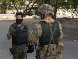 Militares vigilan la zona donde se hallaron los cuerpos decapitados. AFP  /