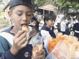Niños de primaria consumen alimentos chatarra afuera de su escuela. A. GARCÍA  /