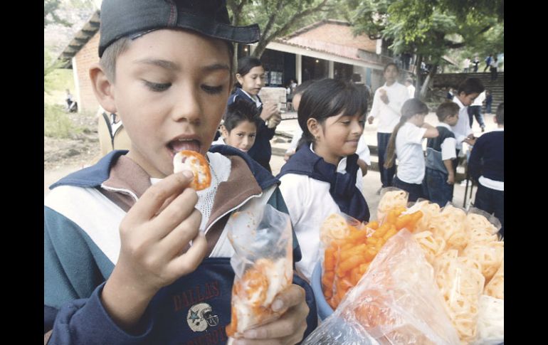 Niños de primaria consumen alimentos chatarra afuera de su escuela. A. GARCÍA  /