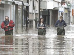 Civiles caminan por una calle inundada por el desbordamiento del Río Mosela. EFE  /