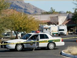 Un elemento del Departamento del Sheriff vigila la entrada al lugar donde se registró el tiroteo en Tucson, Arizona.  AFP  /