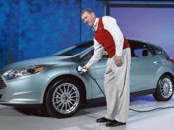 Alan Mulally, director general de Ford, alimenta de energía eléctrica a un Focus, durante su presentación en la feria de Las Vegas. AFP  /