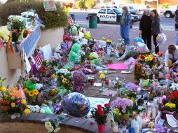 Seguidores y compañeros de la congresista Gabrielle Giffrods permanecen frente al altar que le hicieron fuera de su oficina. AFP  /