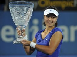 La tenista china Li Na muestra su trofeo tras ganar a la belga Kim Clijsters en la final femenina del torneo de tenis de Sídney. EFE  /