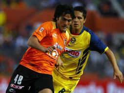 Jorge Hernández, de Jaguares, e Israel Martinez, de América, disputan el control del esférico, hoy, en el Victor Manuel Reyna. MEXSPORT  /