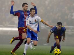 El mediocampista del Real Zaragoza, Gabi Fernández (c), se dispone a tirar a portería ante la presión de los jugadores del Levante. EFE  /
