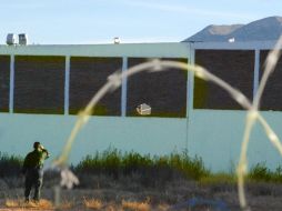 Policía frente al orificio que ayudó a los reos a huir. EFE  /
