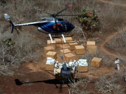 El cebo es arrojado por un helicóptero que sostiene una campana dispensadora. EFE  /