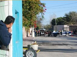 Un hombre observa hacia el lugar donde policías y peritos forenses realizan el levantamiento de cinco cuerpos. EFE  /