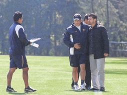De la Torre (der.) saluda al técnico de Pumas, Guillermo Vázquez (centro). MEXSPORT  /