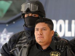 Un elemento de la Policía Federal resguarda a ''El Amarillo'' durante su presentación. AFP  /