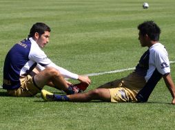 Israel Castro (izq.) realiza unos estiramientos, previo a la práctica de ayer de los universitarios. MEXSPORT  /