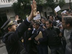 Policía tunecino gesticula al frente de un grupo de personas durante una protesta. EFE  /