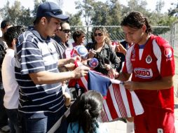 Los jugadores de las Chivas firmando autógrafos en la primera sesión a puerta abierta. M. FREYRIA  /