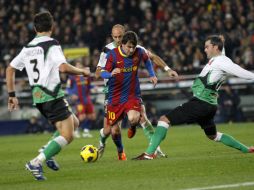 Lionel Messi trata de pasar entre tres defensores del Racing en el juego celebrado en el Camp Nou. REUTERS  /