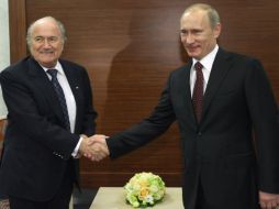 El primer ministro de Rusia Vladimir Putin, se da la mano con el presidente de la FIFA Joseph Blatter. AP  /